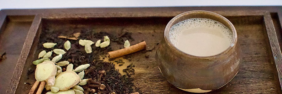Hrejivý masala čaj s mliekom servírovaný so škoricovými tyčinkami Masala čaj ako exotická pochúťka, ktorá rozvonia váš domov