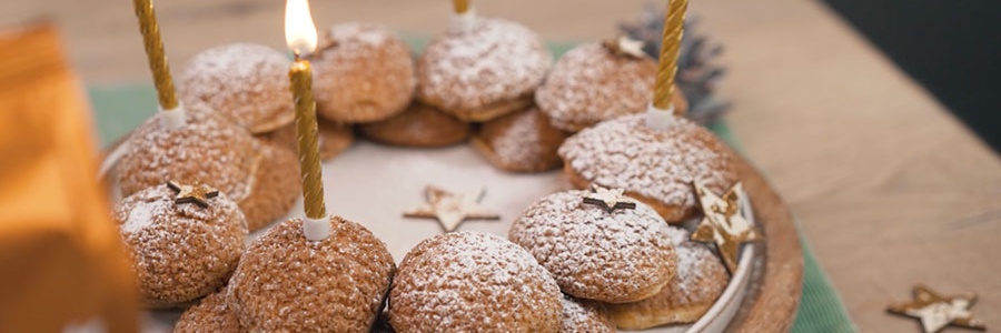 Vianočný veniec z profiteroliek s práškovým cukrom a sviečkami