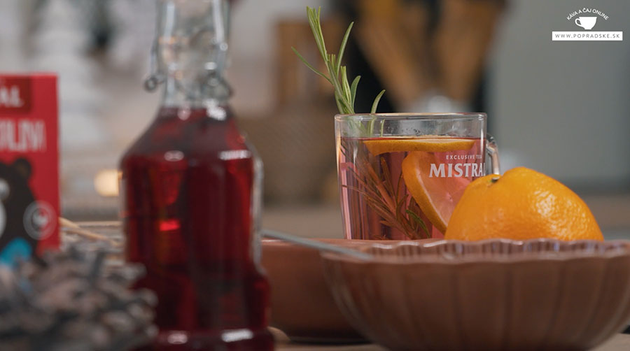 Pohár ovocného punču s plátkom pomaranča a rozmarínom