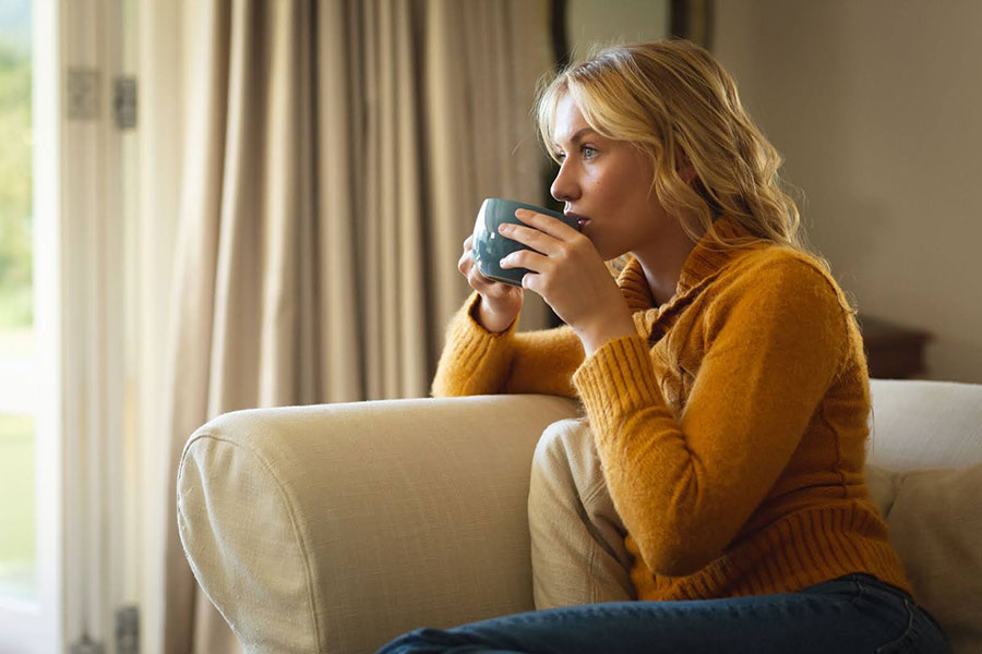 Žena vychutnávajúca si šálku kávy