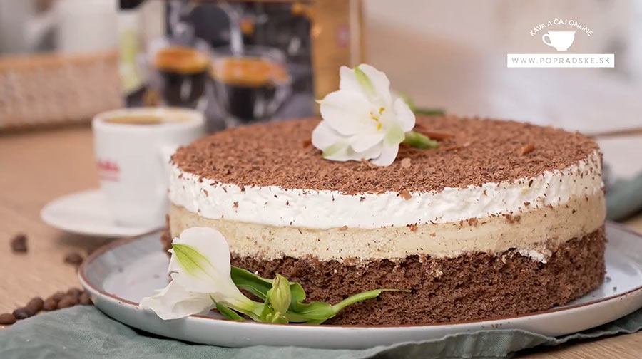 Koláč oblíž prst ako torta zdobený kvetinami pripravený na podávanie s kávou v pozadí
