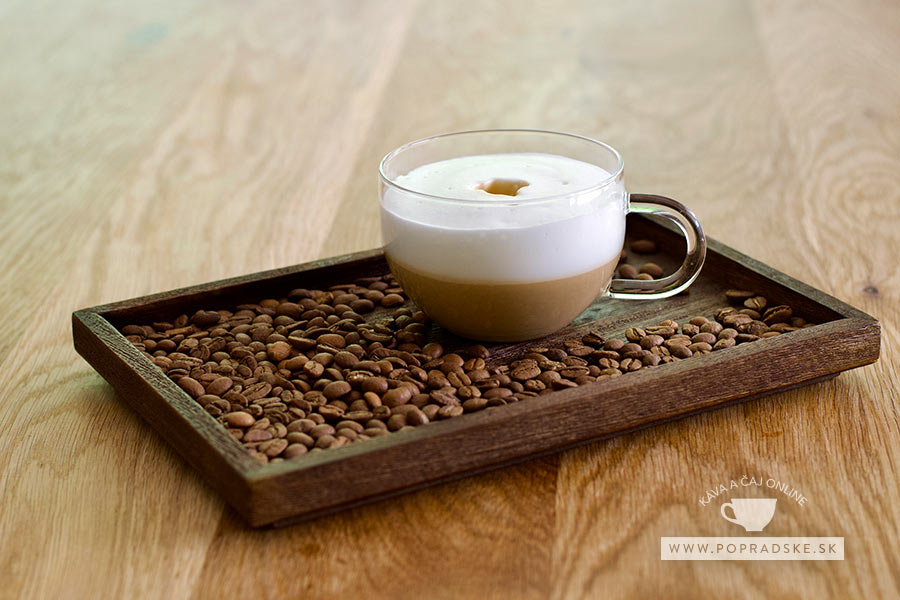 Barista nalieva napenené mlieko z kovovej kanvičky do bielej šálky ako základ prípravy nápoja cappuccino inverso