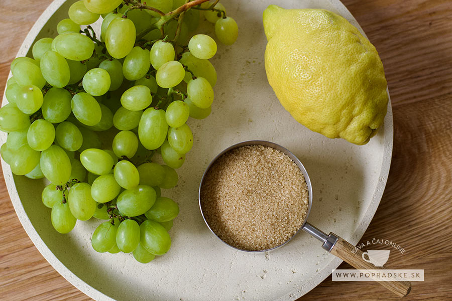 Ingrediencie na hroznový sirup, hrozno, cukor a citrón, položené na bielom tanieri